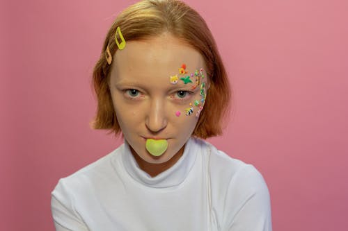 Lady with animal stickers on face blowing bubble with gum