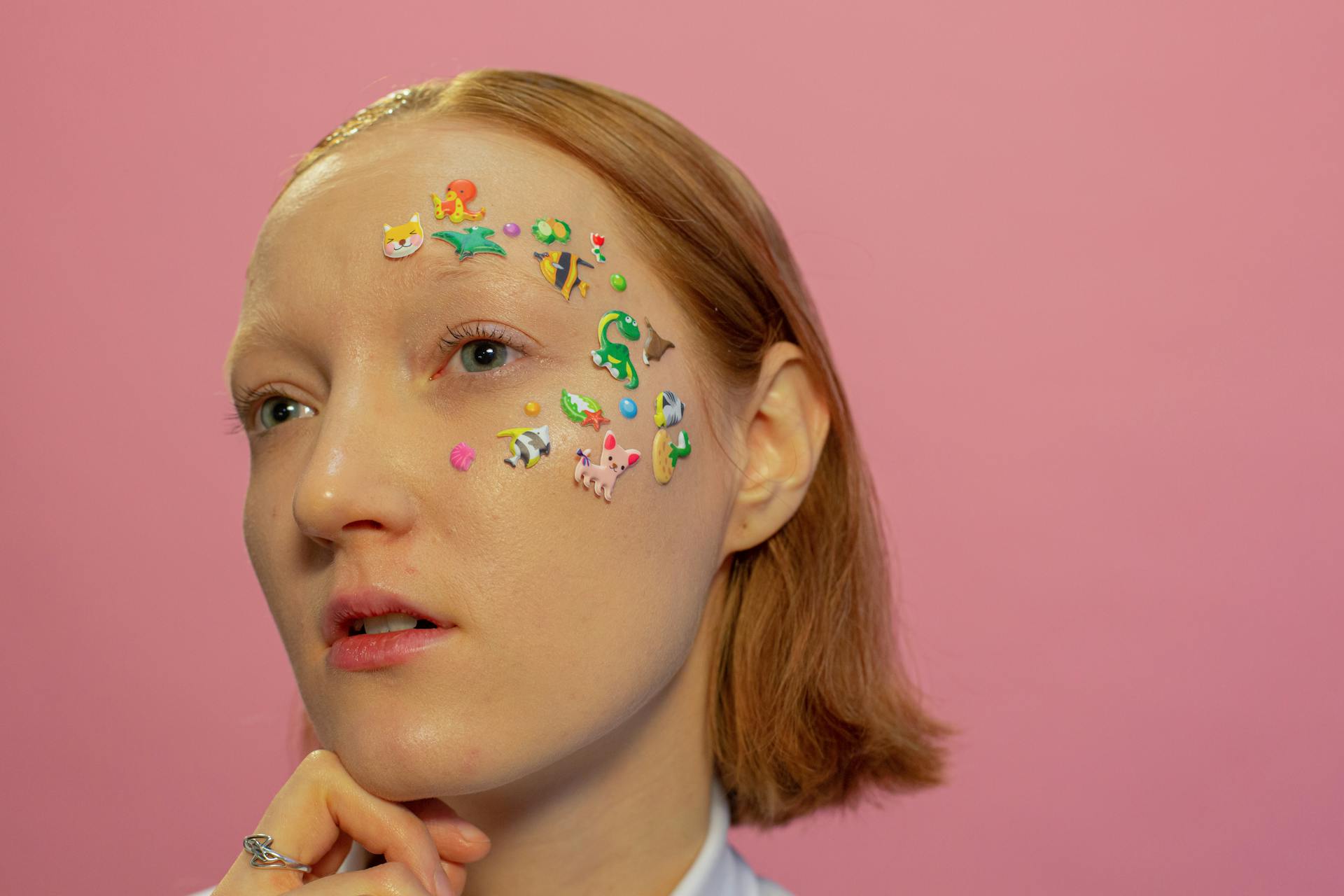 Dreamy lady with animal stickers on face in studio