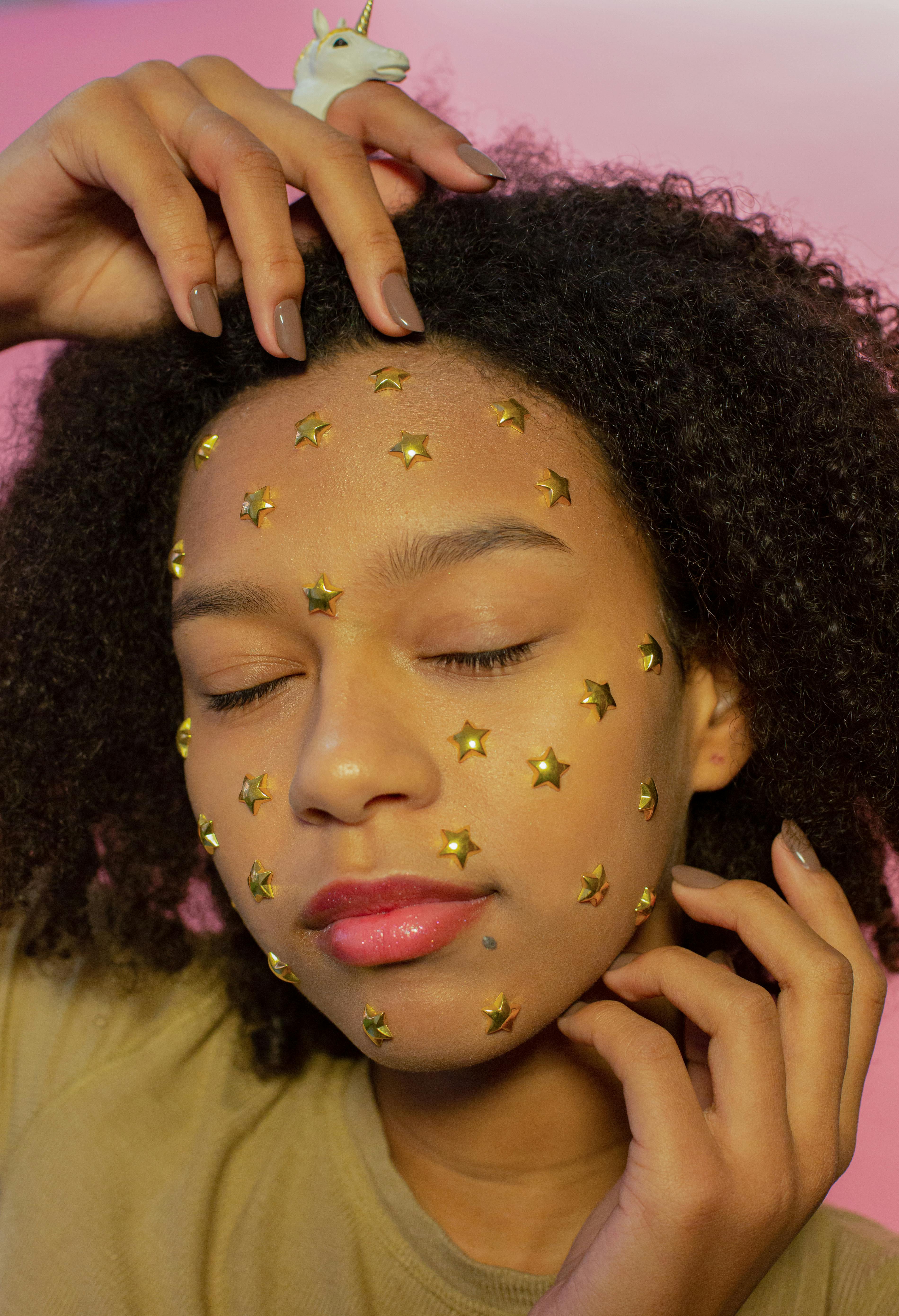 dreamy black female teenager with star stickers on face