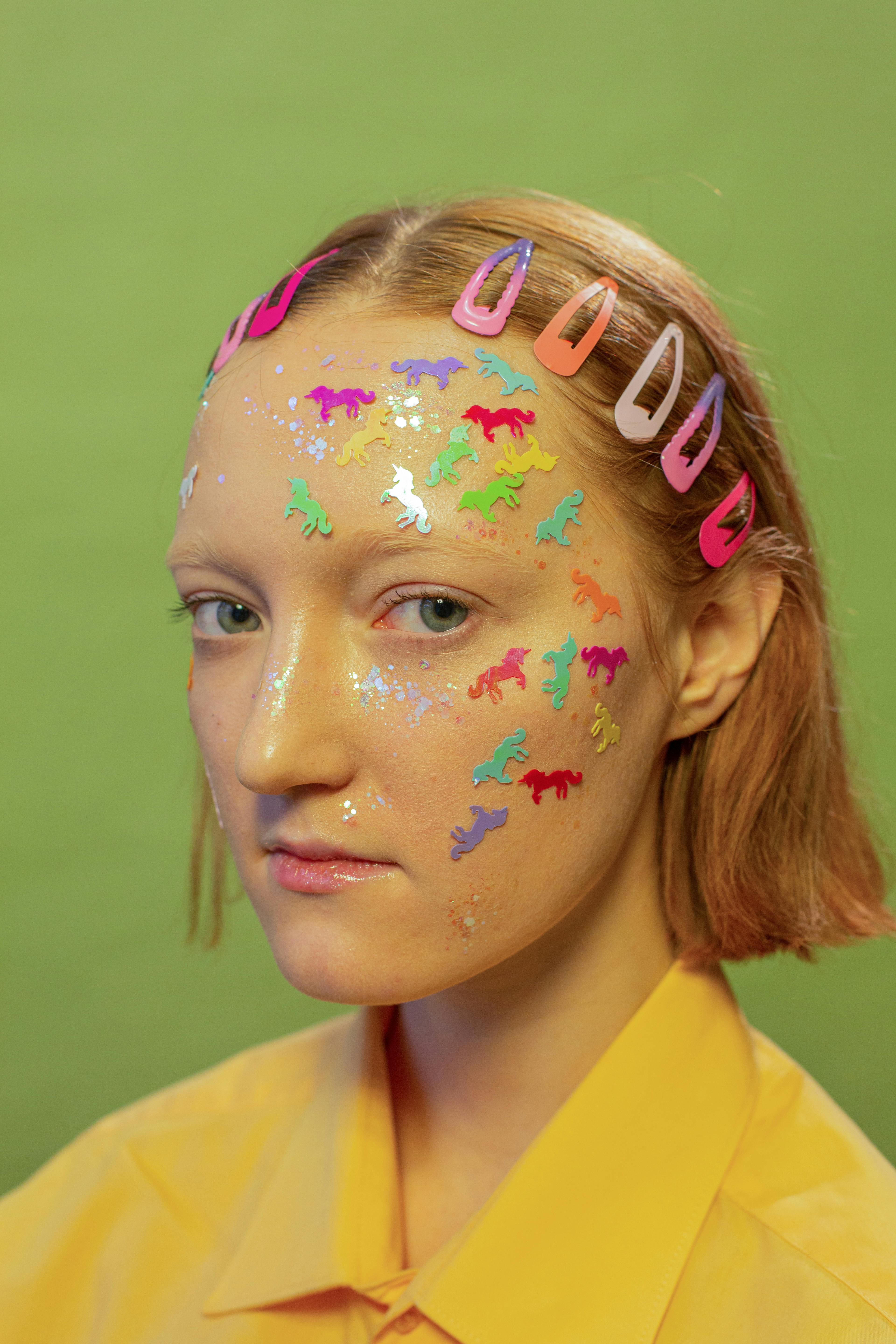 lady with unicorn stickers and glitter on face in studio