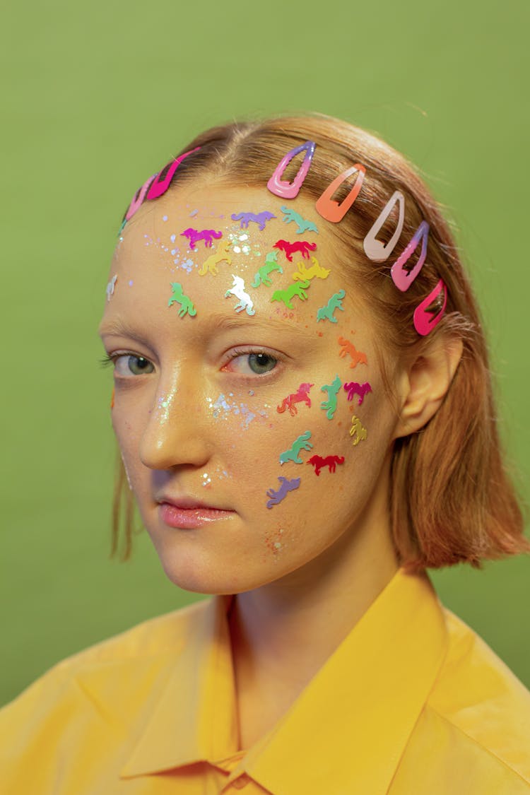 Lady With Unicorn Stickers And Glitter On Face In Studio