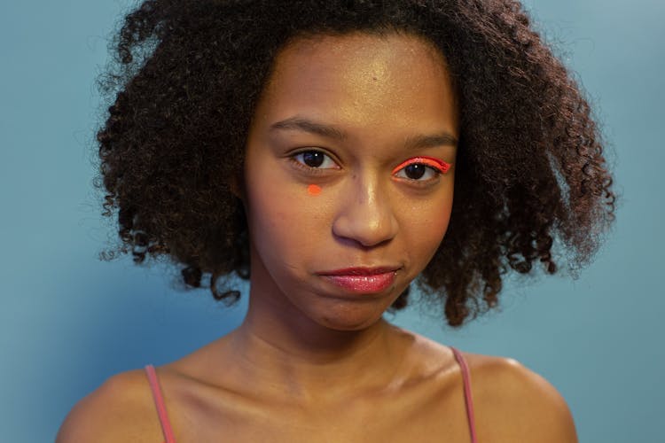 Black Female Teen With Orange Neon Eyeshadow In Studio