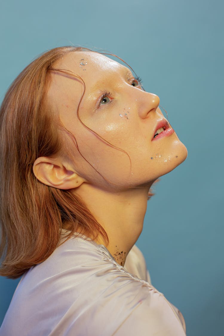 Tranquil Young Female Model Looking Up In Blue Studio