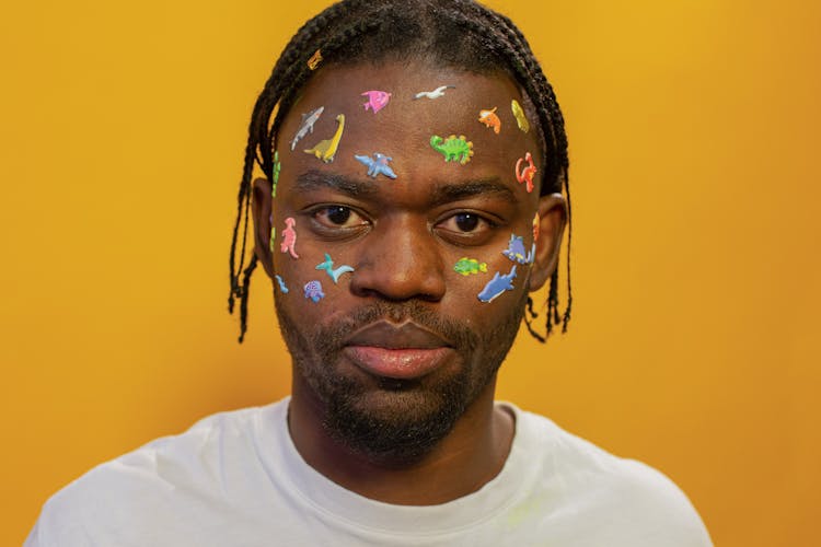 Crop Unemotional Black Man With Childish Stickers On Face