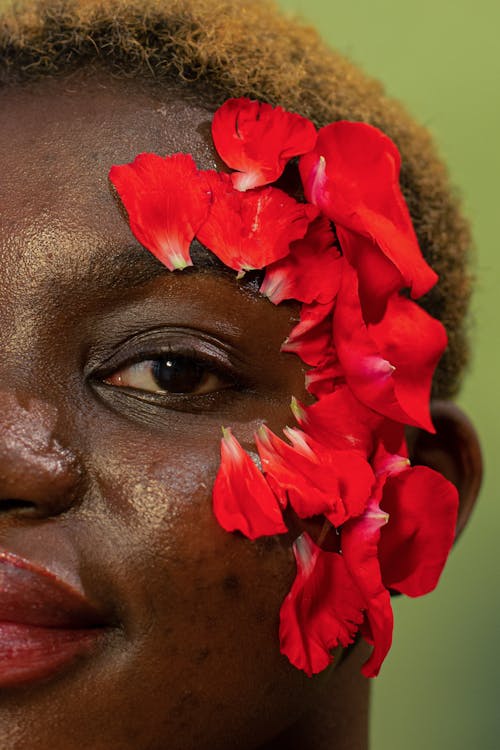 Free Closeup of black young woman with fresh red flower petals on face Stock Photo
