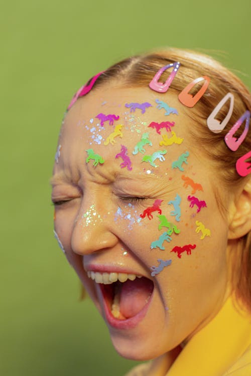 Free Young woman with childish stickers on face shouting in studio Stock Photo