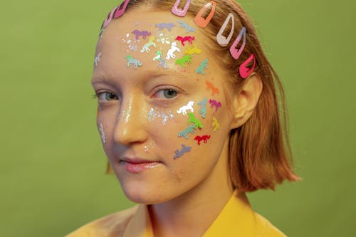 Crop woman with multicolored stickers on face in photo studio