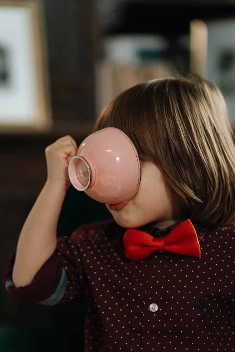 Boy In A Bowtie Drinking Out Of A Cup