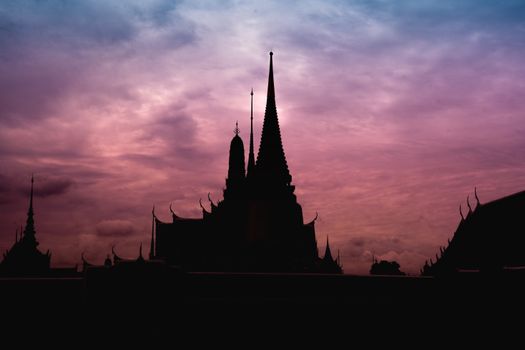 A dramatic temple silhouette against a colorful evening sky, capturing a serene cityscape ambiance.