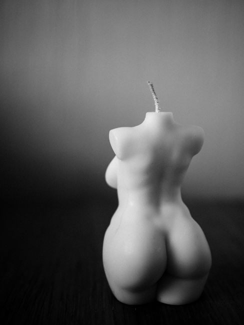 Elegant monochrome candle shaped as a human form in a serene still life setting.