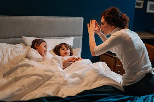Free A Woman Story Telling with Two Children in Bed Stock Photo