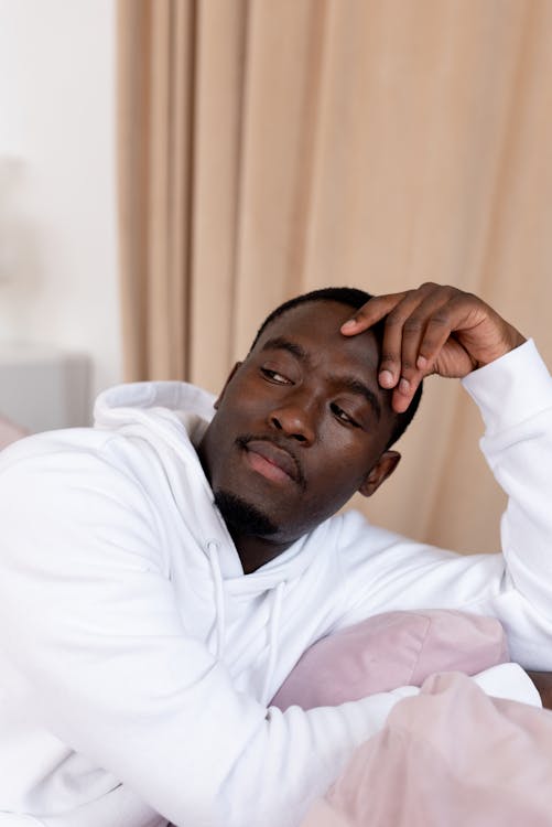 Free Pensive black man sitting in living room Stock Photo