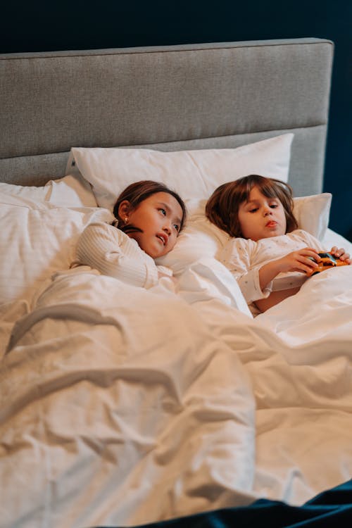 Free Children in Bed with White Linens Stock Photo