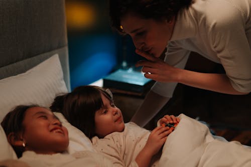 Free Woman Silencing Two Children to Bed Stock Photo