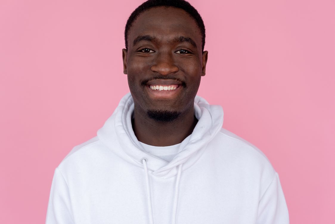 Smiling black man wearing hoodie in studio · Free Stock Photo