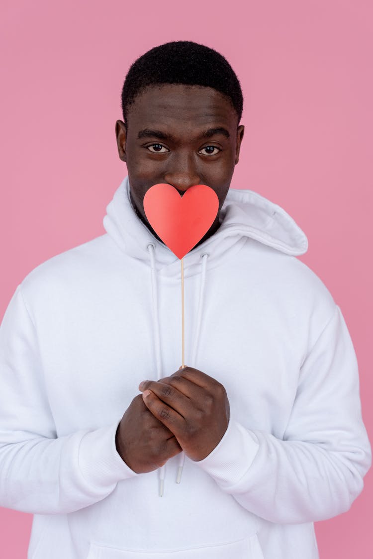 Black Man Covering Mouth With Heart On Stick