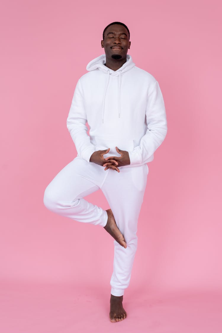 Smiling Black Man Balancing On Leg In Studio