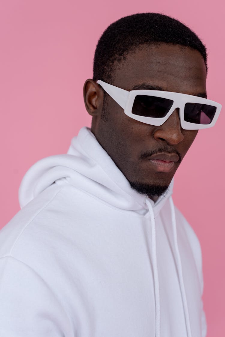 Confident Black Man In White Sunglasses And Hoodie In Studio