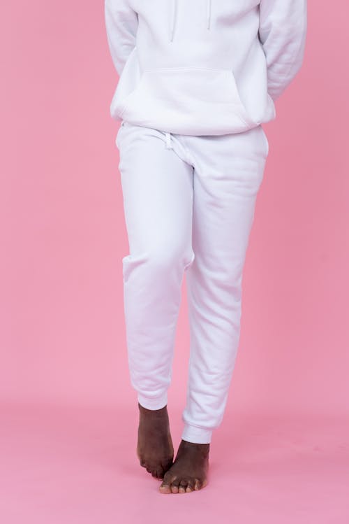 A Person in White Sweater and Pants Standing Barefooted