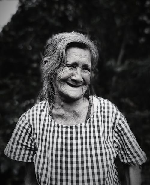 Free A Grayscale Photo of an Elderly Woman in Checkered Shirt Smiling Stock Photo
