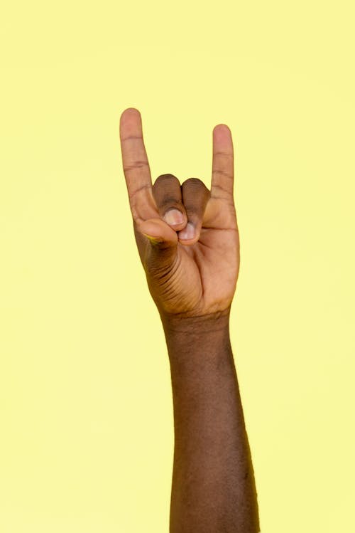 Hand on Yellow Background Showing Gesture 