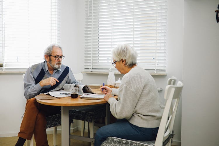 Elderly Couple Sitting In A Dining Area