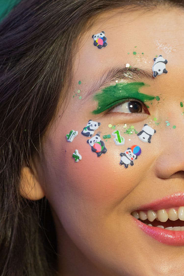 Crop Smiling Asian Woman With Bright Makeup Stickers On Face