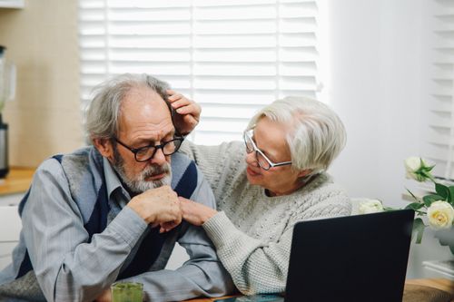 Free An elderly couple at home engaging with technology on a laptop in a modern setting. Stock Photo