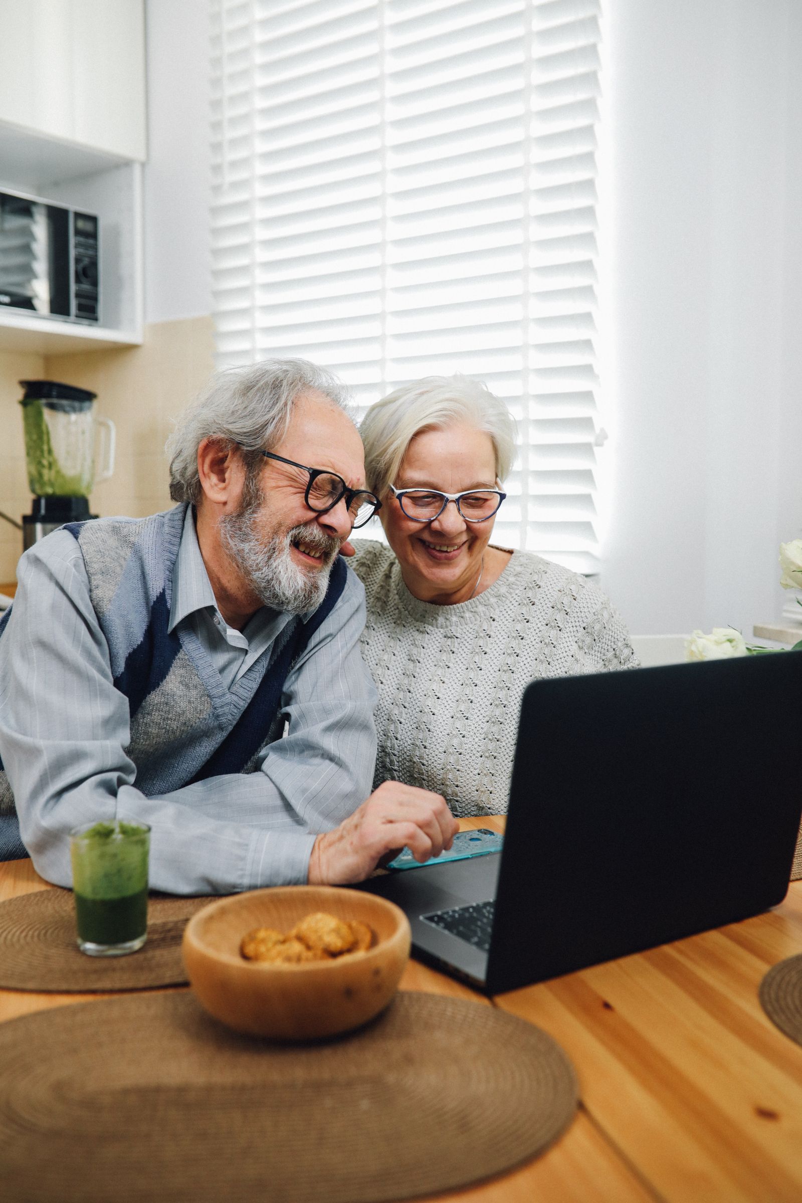 Older couple revisiting family stories together on a laptop