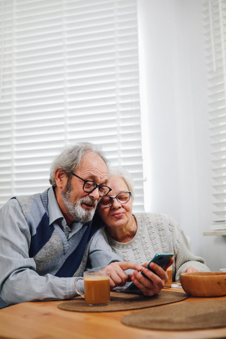 Happy Old Couple Using Mobile Phone Together