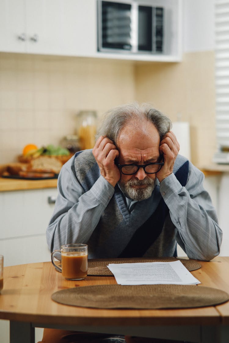 Close-Up Shot Of An Elderly Man With Eyeglasses Looking At The Paper