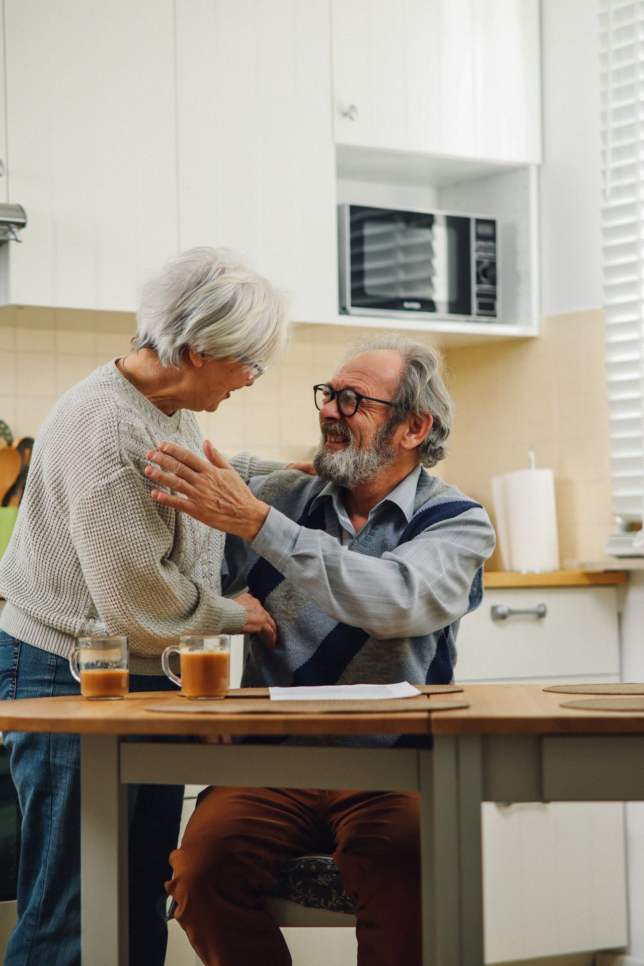 Happy senior couple sharing a warm moment in their kitchen