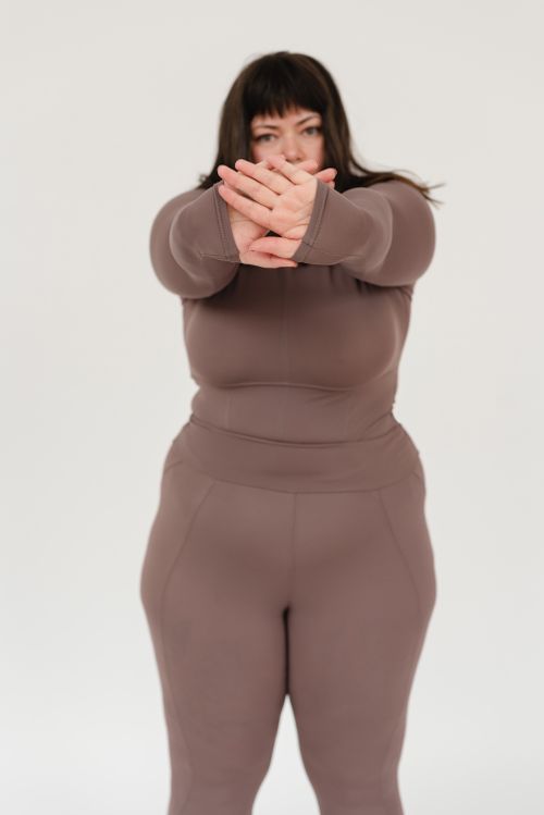 Free Serious plus size female in sportswear demonstrating rejection gesture in studio against white background and looking at camera Stock Photo