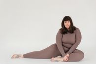 Overweight woman in activewear sitting in studio during training
