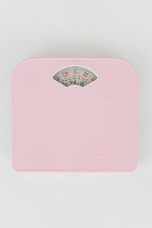 Pink Weighing Scale on a White Surface 