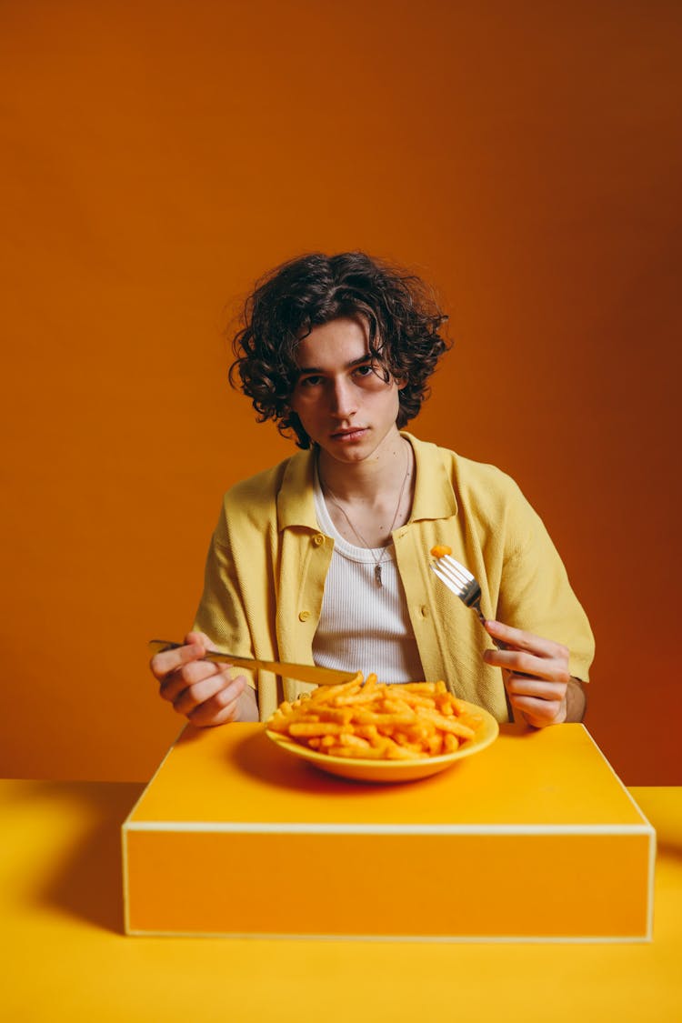 Man Eating A Bowl Of Fried Potatoes