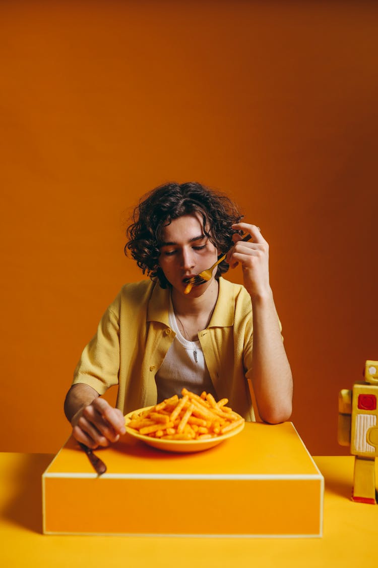 A Young Man Eating French Fries