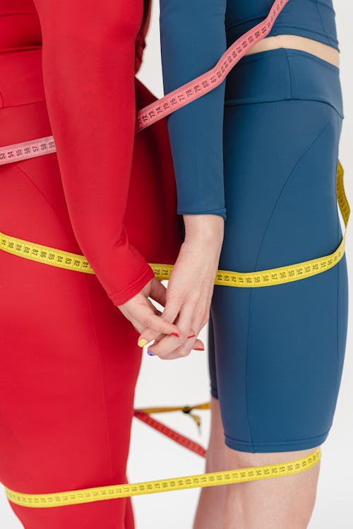 Crop sporty women covered with measuring tapes