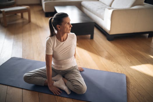 Elderly woman in activewear practicing yoga at home on a sunny day.