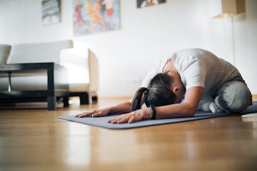 A woman practicing yoga in a serene living room setting, emphasizing healthy living.
