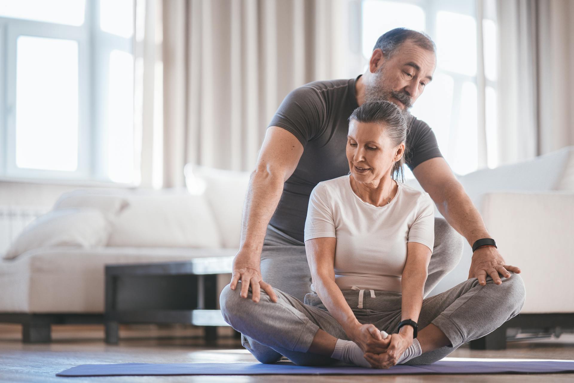 Senior couple engaged in yoga exercise at home, focusing on flexibility and mindfulness.