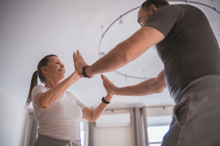 A Couple Doing Yoga Pressing Their Hands Together