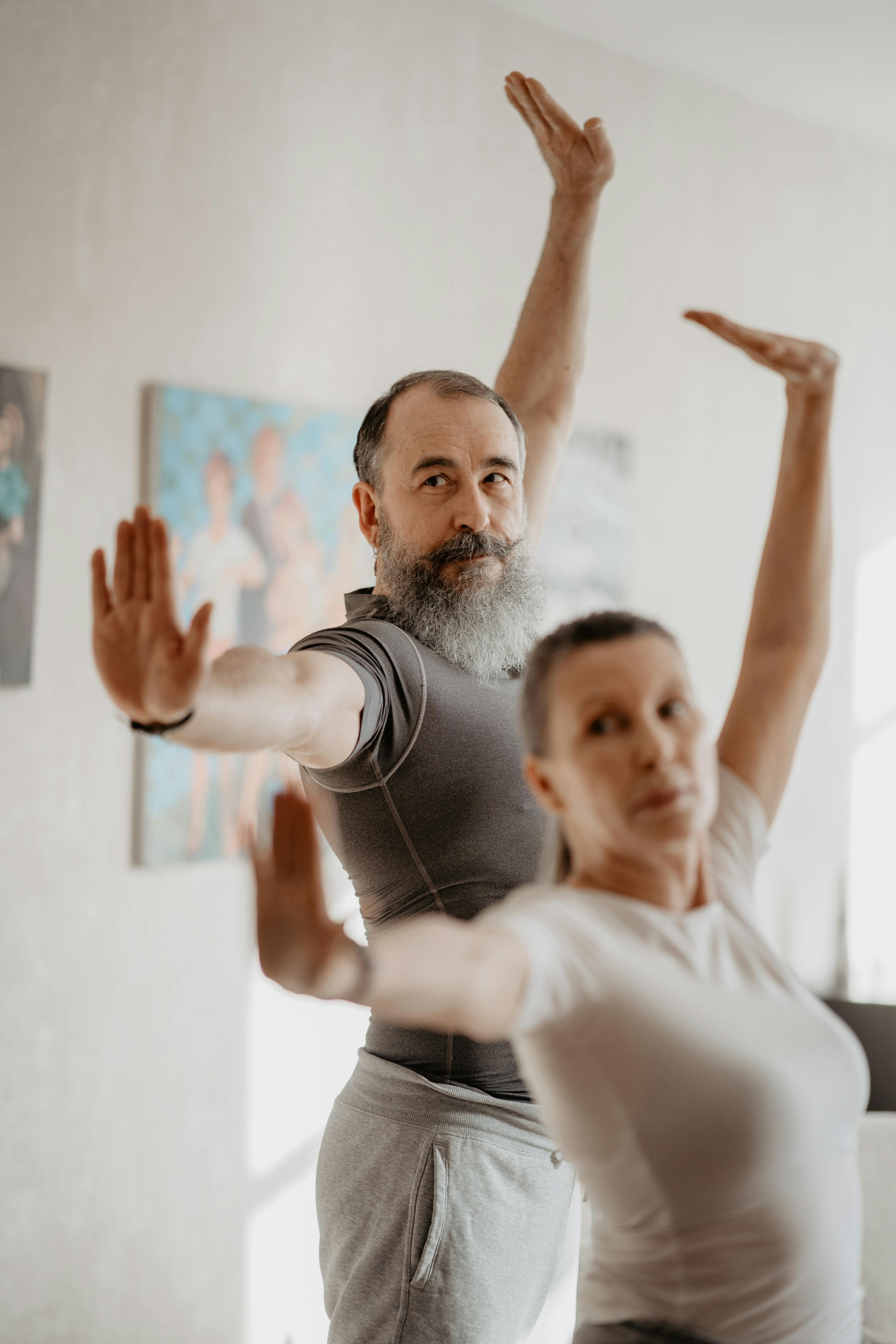 an elderly man and woman doing yoga