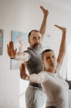 Senior couple engaging in yoga exercises indoors, promoting a healthy lifestyle and well-being.