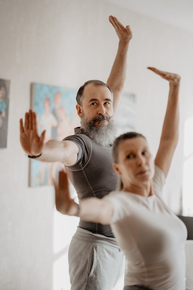 An Elderly Man And Woman Doing Yoga