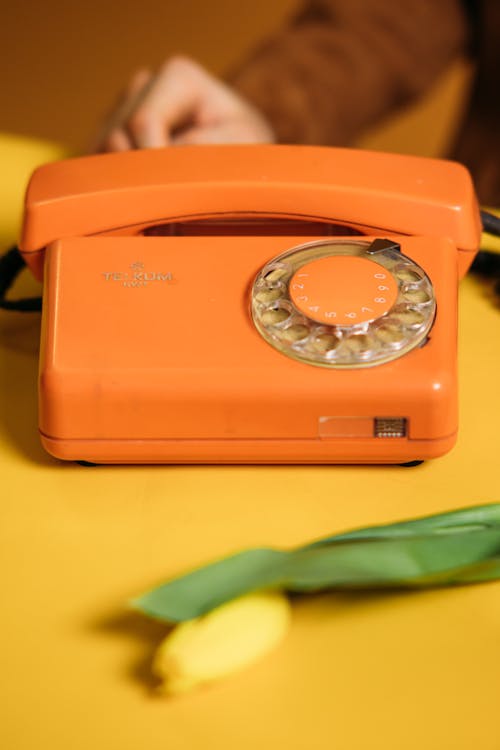 Free Orange Vintage Telephone On Yellow Table Stock Photo