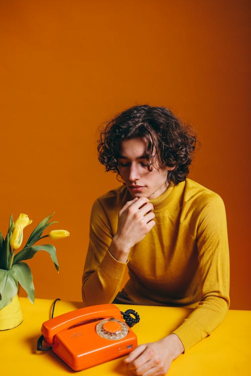 Free Young Man in Yellow Long Sleeve Shirt Feeling Pensive Stock Photo