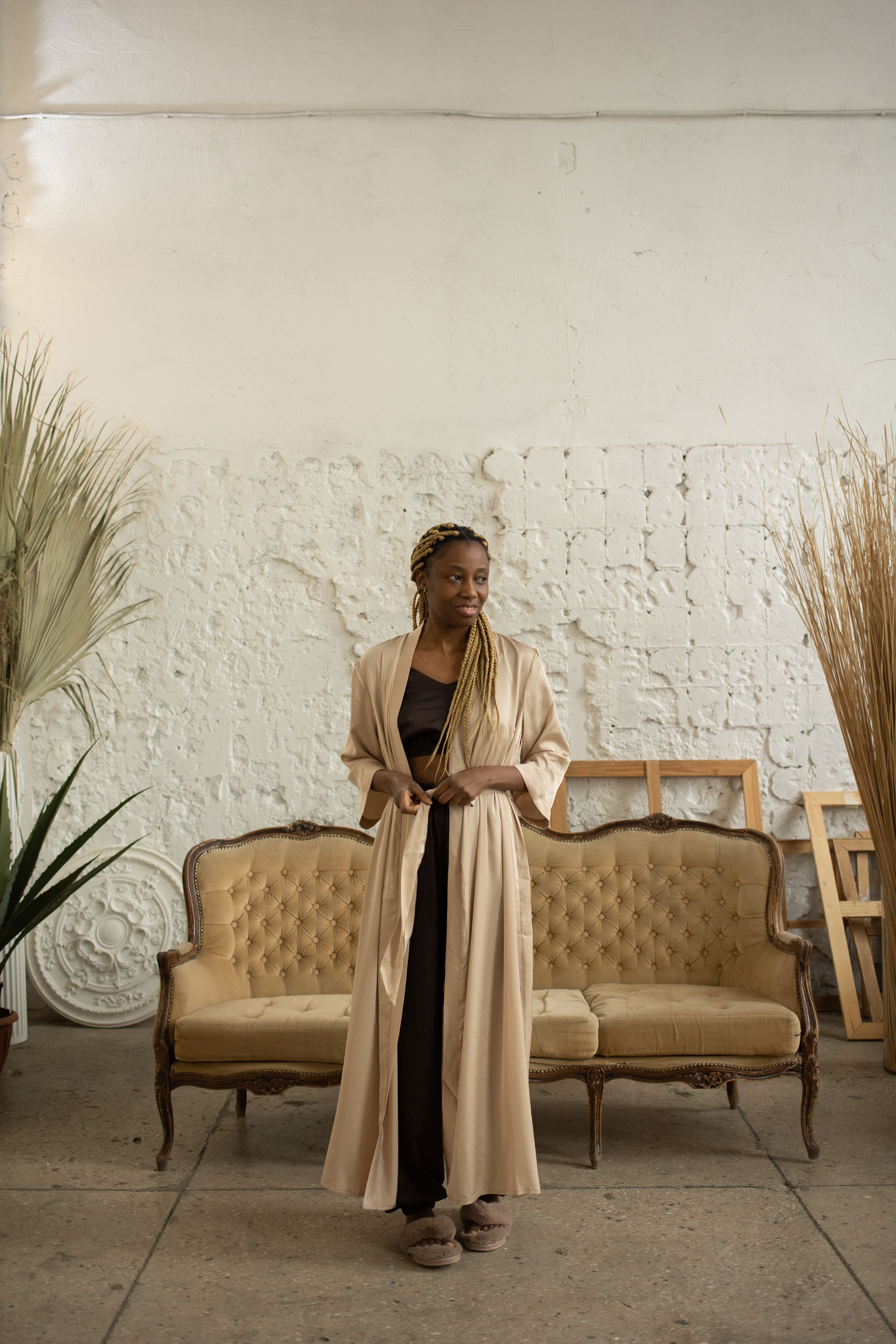 A Woman Wearing a Robe while Standing Near the Couch · Free Stock Photo