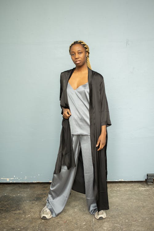 A Woman in Black Robe Standing on a Concrete Floor