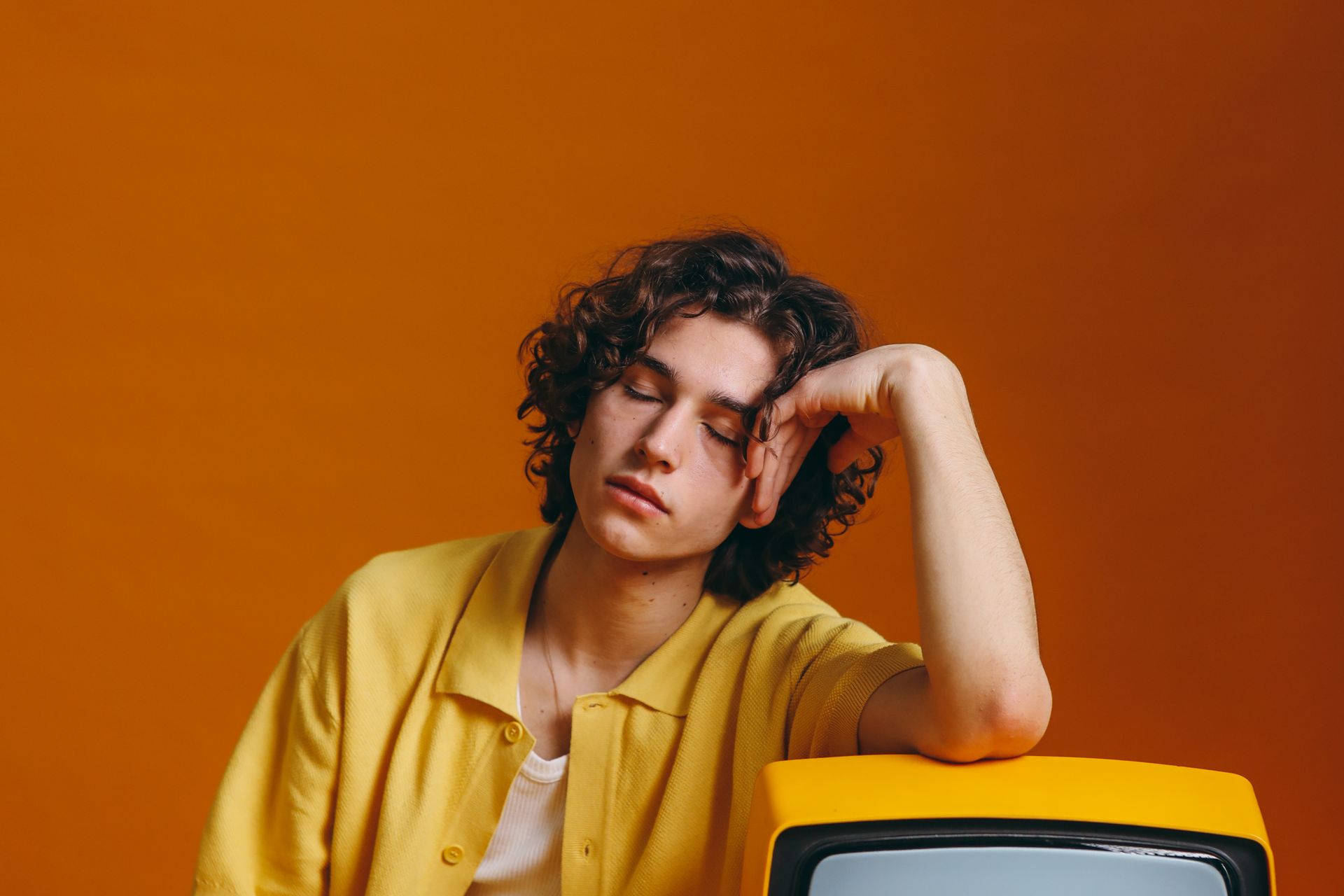 Young Man Sleeping Beside A Yellow Tv